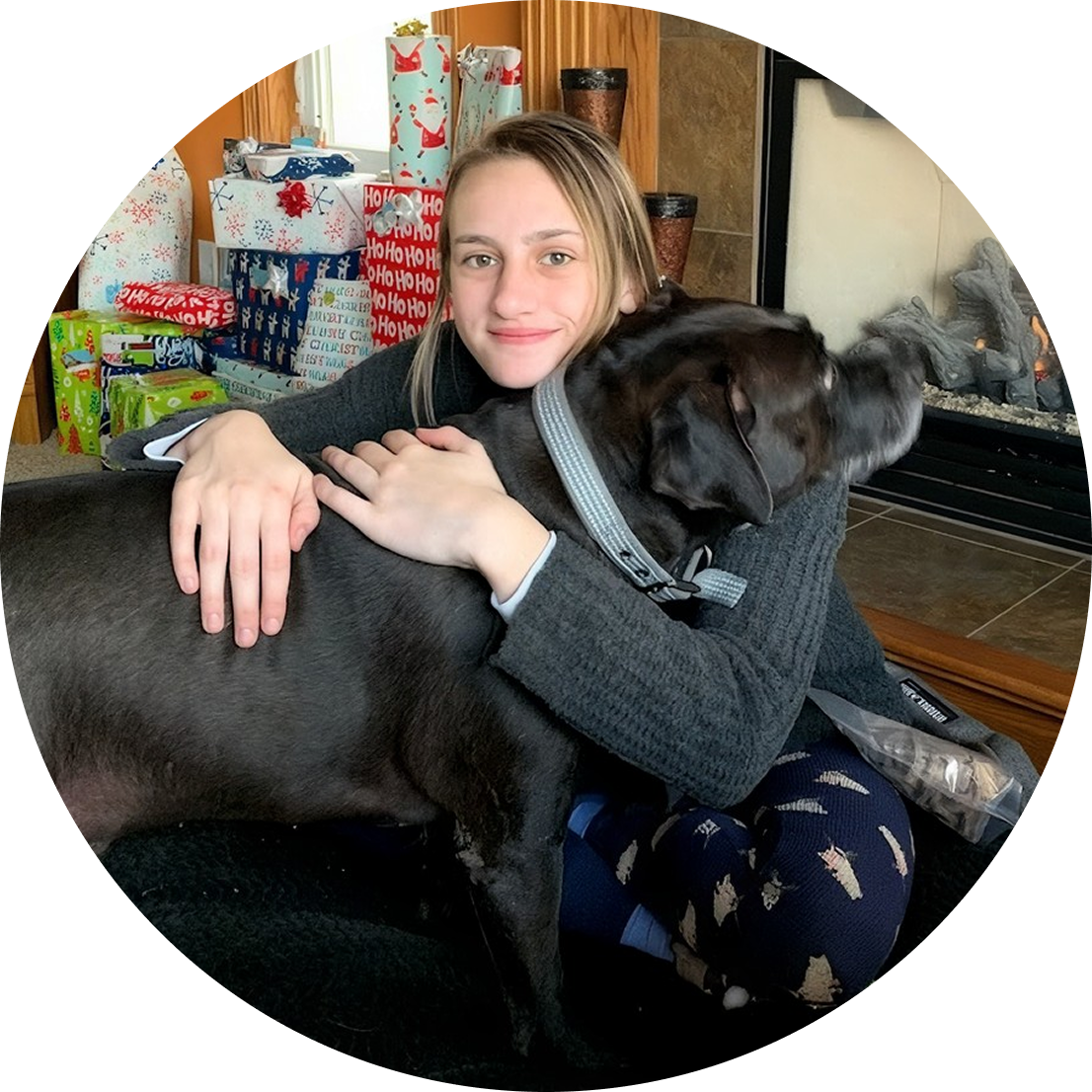 Girl hugging a black dog at home